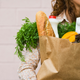 woman holding bag of groceries